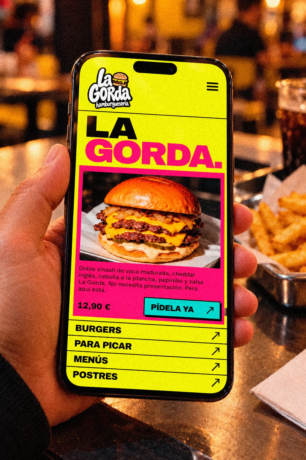 Una mano sujeta un móvil con la web de La Gorda abierta en la carta