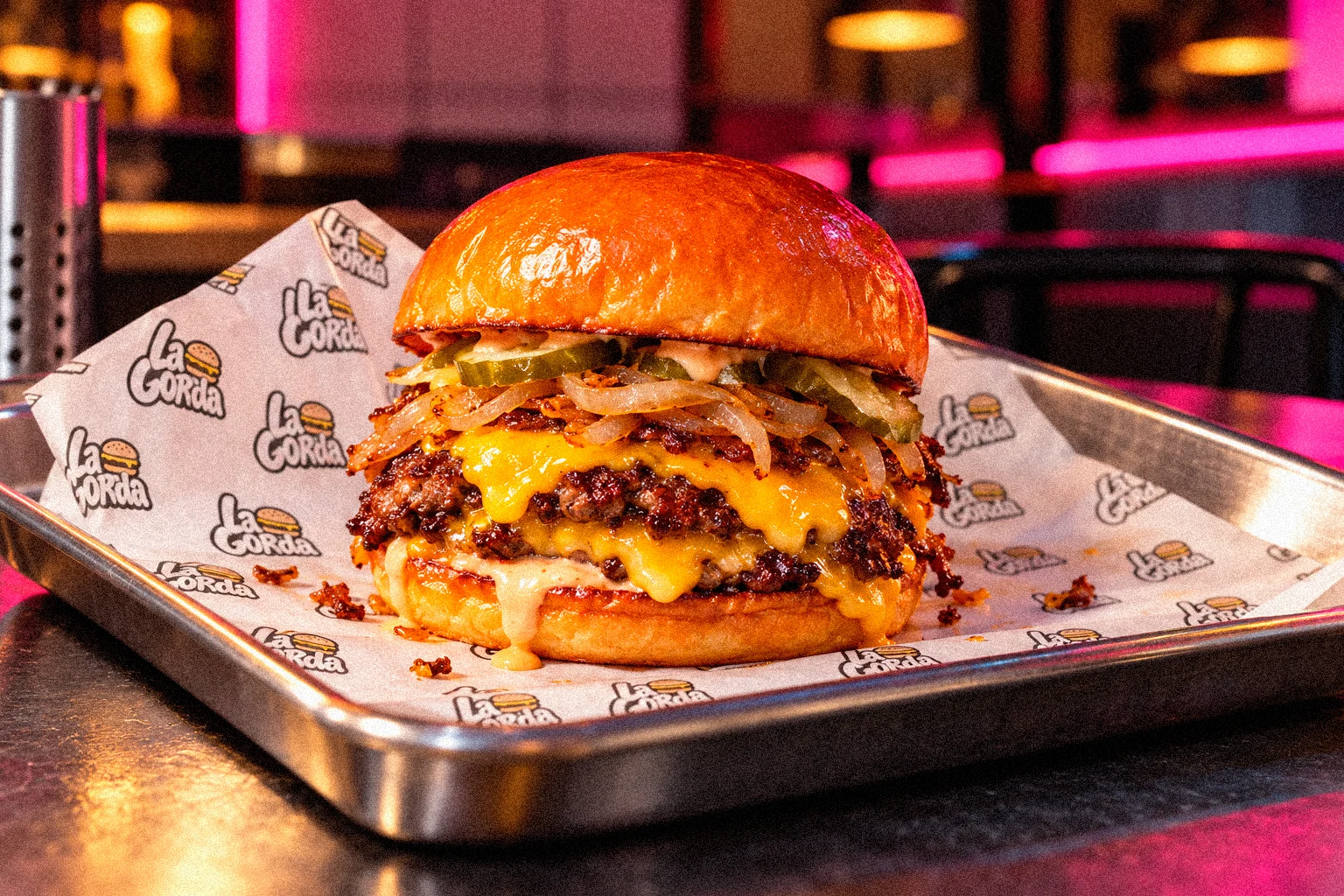 Hamburguesa La Gorda sobre papel antigrasa con el estampado de la marca